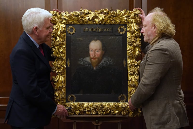 Conservator Adrian Phippen, right, and art and antiques writer Duncan Phillips with the portrait of William Shakespeare by Robert Peake.  PA