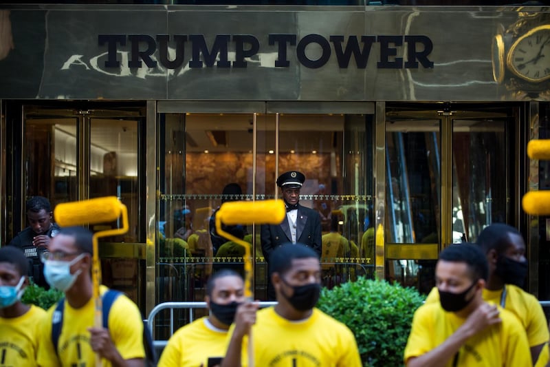 Volunteers from Street Corner Resources hold up paint rollers during the painting of a 'Black Lives Matter' mural along Fifth Avenue in front of Trump Tower in New York. Bloomberg