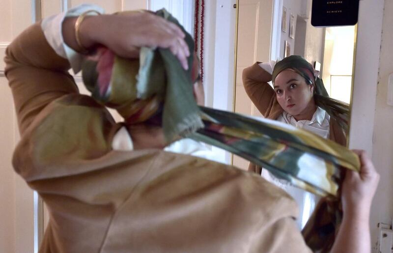 French reseacher and Muslim-feminist Hanane Karimi adjusting her hijab at her home in Strasbourg, eastern France, on August 24, 2016. Patrick Hertzog/AFP



