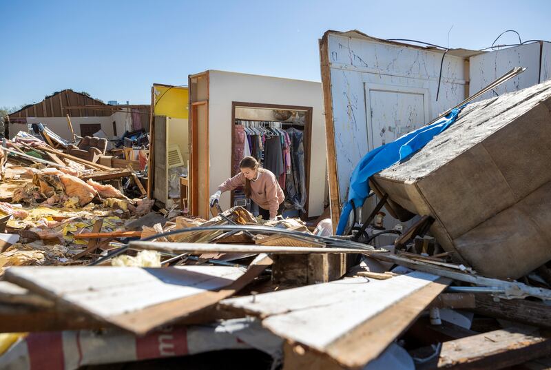 Korey Miller, 23, looks for valuables and family heirlooms in her grandmother's home in Gretna, Louisiana, after the entire roof was blown away by a tornado.  AP