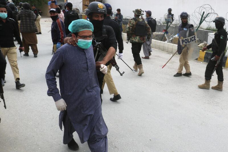 FILE PHOTO: A police officer detains a doctor who along with others demonstrates against the lack of protective gears for medical staff who are treating coronavirus disease (COVID-19) patients in Quetta, Pakistan April 6, 2020 REUTERS/Naseer Ahmed/File Photo