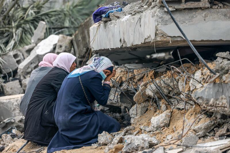 Palestinian women cry where a relative is believed to be trapped in debris following Israeli bombardment in Rafah in the southern Gaza Strip on December 21, 2023, amid continuing battles between Israel and the militant group Hamas.  AFP