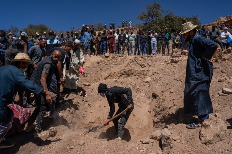Mourners watch as a grave is dug for a man killed by the earthquake, in Douzrou, Morocco. Getty Images