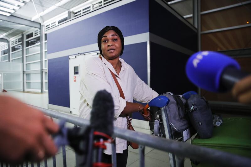Raissa Kalembho, who was visiting her husband with their children in Niger, speaks to journalists after landing at Paris Charles de Gaulle airport. EPA