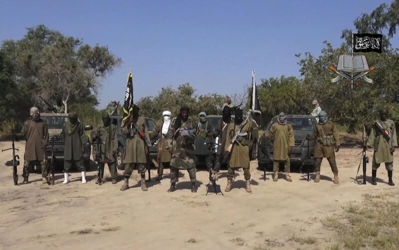 FILE - In this file image taken from video released Friday Oct. 31, 2014, by Boko Haram, Abubakar Shekau, centre, the leader of Nigeria's Islamic extremist group, surrounded by his fighters. Nigeria-based Boko Haram extremists have killed more than 380 people in the Lake Chad region since April, a major resurgence of attacks that has resulted in double the casualties compared to the five months before April, Amnesty International said Tuesday, Sept. 5, 2017. (AP Photo/Boko Haram,File)