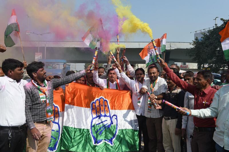 Indian Congress party supporters hold Congress party flag as they celebrate in Ahmedabad on December 11, 2018. India's ruling party looked set to lose power in at least one of three traditional stronghold states releasing election results on December 11, in a blow to Prime Minister Narendra Modi ahead of national polls in 2019. / AFP / SAM PANTHAKY

