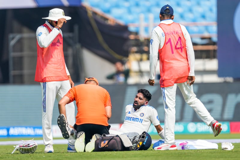 A physio attends to India's Mohammed Siraj, who was injured playing a reverse sweep. AP 
