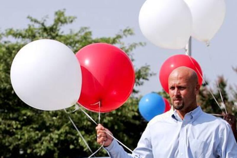 A sales manager who declined identification ties balloons to General Motors Chevrolet vehicles on a dealership lot in Wake Forest, North Carolina, U.S., on Saturday, June 27, 2009. General Motors Corp. (GM) is poised to follow rival Chrysler LLC's path and win approval to sell most of its assets at a hearing set to start today, putting President Barack Obama's administration almost a month ahead of schedule in its plan to reshape the U.S. auto industry. Photographer: Jim R. Bounds/Bloomberg News