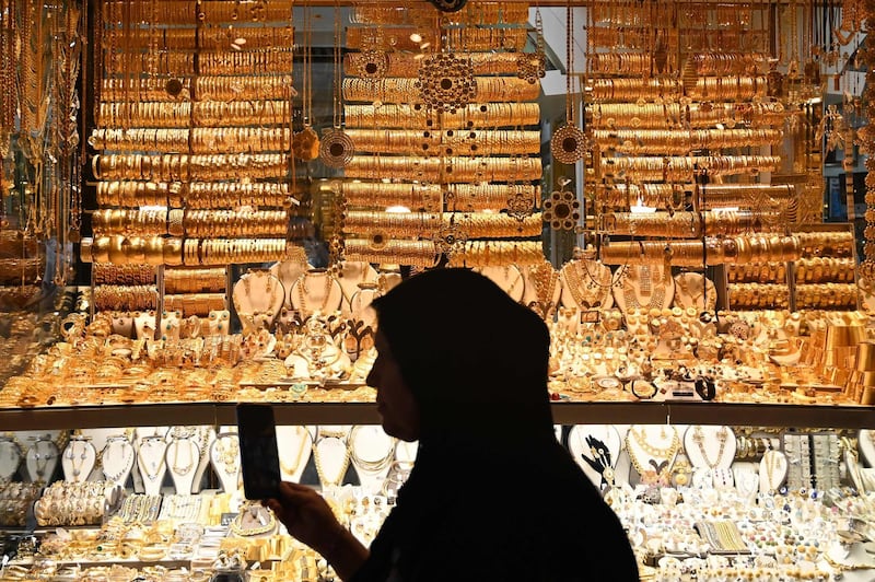 A woman walks past a gold shop on July 13, 2019 at the historical spice bazaar at Eminonu district in Istanbul.  / AFP / Ozan KOSE
