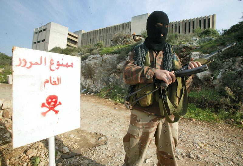 A masked militant of the Popular Front for the Liberation of Palestine-General Command stands guard at the entrance to a military base of the pro-Syrian organization which was attacked by Israeli jets, in Naameh, 20 kms south of Beirut, 28 December 2005. Israeli warplanes targetted the PFLP-GC post lightly wounding two militants in the first air raid so close to the Lebanese capital in 18 months. Israeli commanders said the strike was in retaliation for overnight rocket fire on the border town of Kiryat Shmona but Taja denied that his group fired rockets at Israel.  AFP PHOTO/HAITHAM MUSSAWI (Photo by HAITHAM MUSSAWI / AFP)