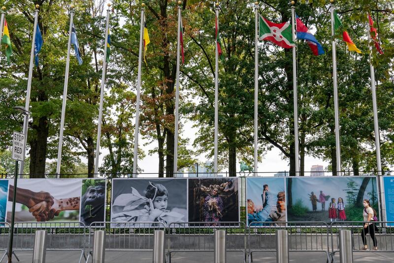 A woman wearing a face mask to protect against the coronavirus walks past artwork and metal barricades lining the sidewalk outside the United Nations headquarters in New York. AP Photo