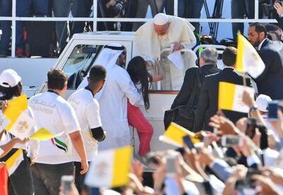 Pope Francis blesses a young girl as he arrives to lead mass for an estimated 170,000 Catholics at an Abu Dhabi sports stadium on February 5, 2019. / AFP / Vincenzo PINTO                      
