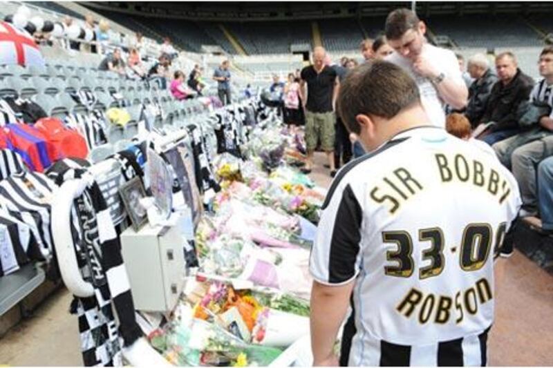 A Newcastle fan looks at the floral tributes to Sir Bobby Robson at St James' Park, Newcastle.
