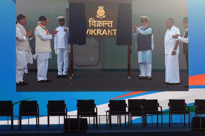 Mr Modi, third right, appears on a large screen as he unveils a name plaque during the commissioning ceremony. AFP