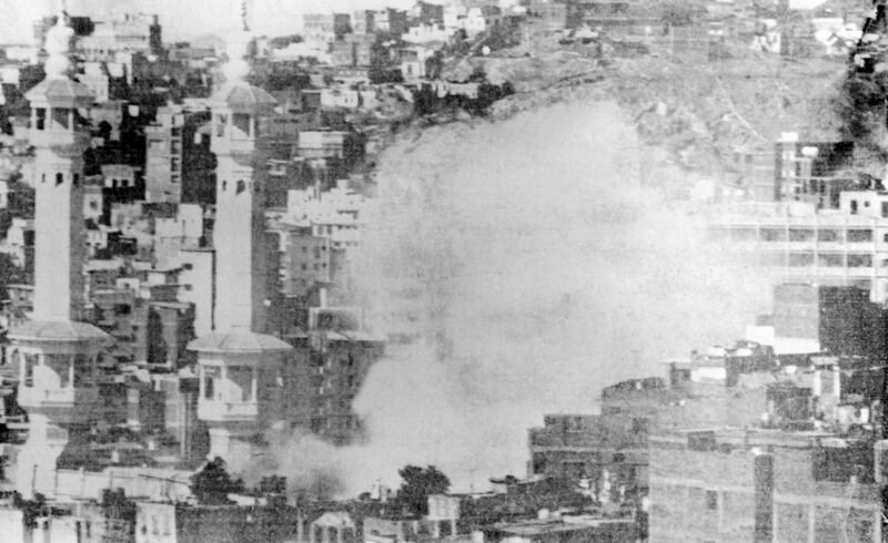 TO GO WITH AFP STORY BY PAUL HANDLEY
(FILES) A picture taken in November 1979 shows smoke billowing from Mecca's Great Mosque, which was attacked on November 20, 1979 by gunmen belonging to a group commanded by Juhayman al-Oteibi, alias "Lieutenant Mahdi" (the Messiah). Thirty years ago, as tens of thousands of hajj pilgrims were completing dawn prayers inside Mecca, gunshots pierced the sanctity of the Grand Mosque. To mark a new century on the Islamic calendar, a group of millennialist zealots, who claimed to have with them the new redeemer -- the mahdi -- seized Islam's holiest site. AFP PHOTO/STR (Photo by FILES / AFP)