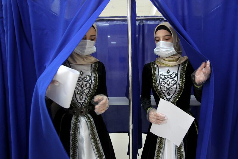 Chechen women wearing traditional costume leave a polling booth in Grozny, Russia. AP