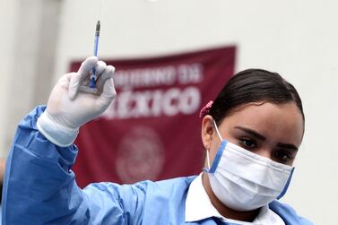 A nurse holds a syringe of a dose of the AstraZeneca Covid-19 vaccine in Guadalajara, Mexico in April 2022. The drug firm is to cease production of the shots. AFP