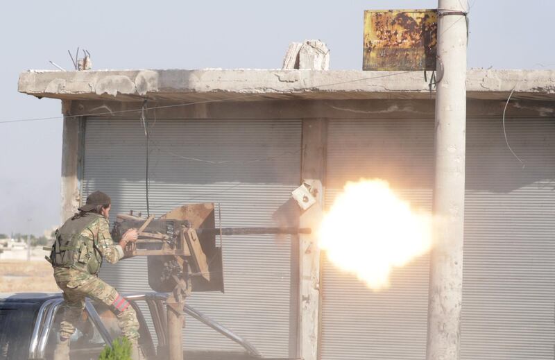 A Turkey-backed Syrian rebel fighter fires a weapon in the town of Tal Abyad, Syria. Reuters
