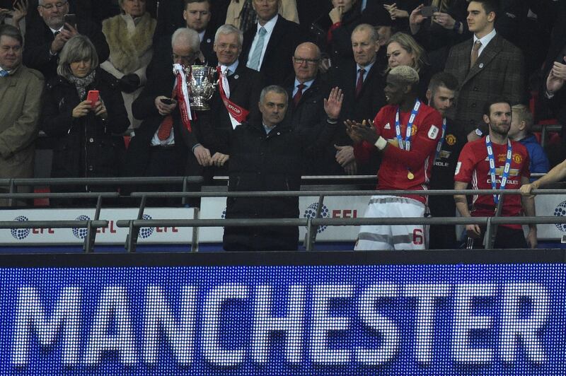 Manchester United's Portuguese manager Jose Mourinho holds up the trophy as Manchester United players celebrate their victory after the English League Cup final football match between Manchester United and Southampton at Wembley stadium in north London on February 26, 2017. - Zlatan Ibrahimovic sealed the first major silverware of Jose Mourinho's Manchester United reign and broke Southampton's hearts as the Swedish star's late goal clinched a dramatic 3-2 victory in Sunday's League Cup final. (Photo by Glyn KIRK / AFP) / RESTRICTED TO EDITORIAL USE. No use with unauthorized audio, video, data, fixture lists, club/league logos or 'live' services. Online in-match use limited to 75 images, no video emulation. No use in betting, games or single club/league/player publications. / 