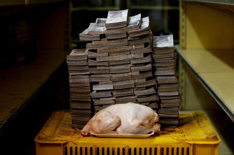 A 2.4 kg chicken is pictured next to 14,600,000 bolivars, its price and the equivalent of 2.22 USD, at a mini-market in Caracas, Venezuela. Reuters