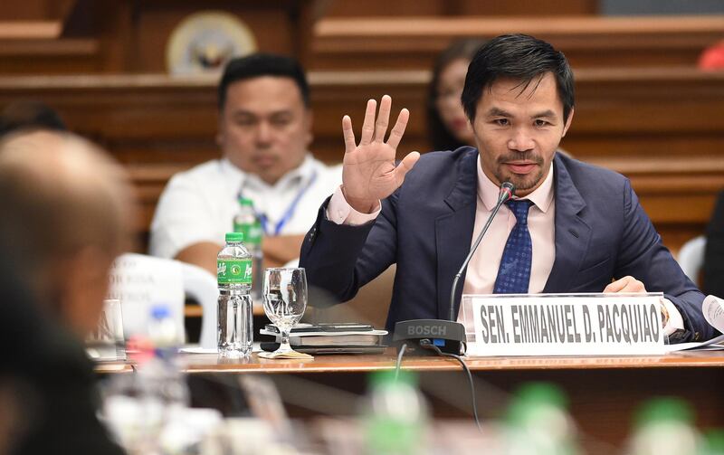 Philippine boxing icon and Senator Manny Pacquiao (R) gestures as he asks questions to retired police officer Arturo "Arthur" Lascanas (L) at a Senate hearing in Manila on March 6, 2017. - The former police aide of Philippine President Rodrigo Duterte said he was part of a "death squad" that took part in over 300 killings when Duterte was a city mayor. (Photo by TED ALJIBE / AFP)