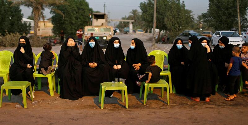 Iraqi Shiite women wear masks and rest as they make their way to Kerbala ahead of the Shiite ritual of Arbaeen. Reuters