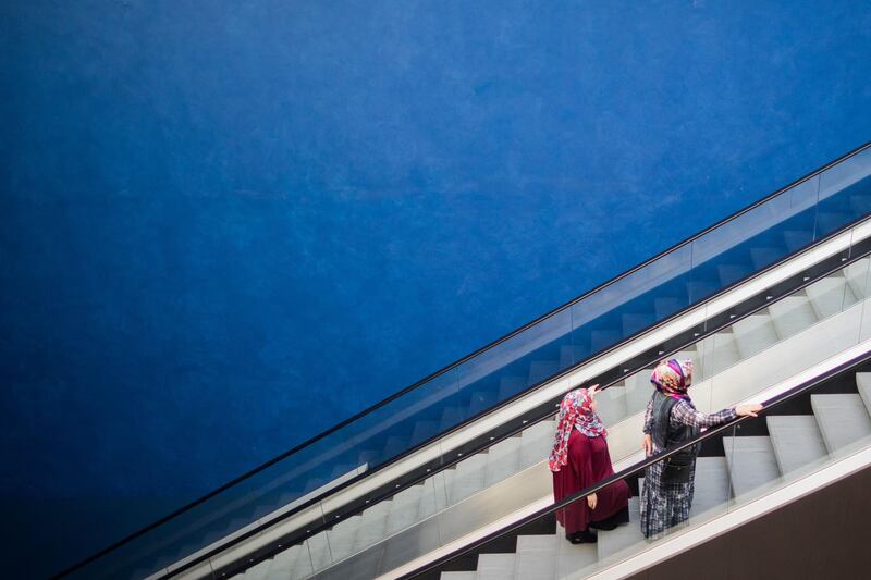 Two women stand on an elevator as they arrive to cast their votes for Turkey's presidential elections in Essen, western Germany. Rolf Vennenbernd / AFP