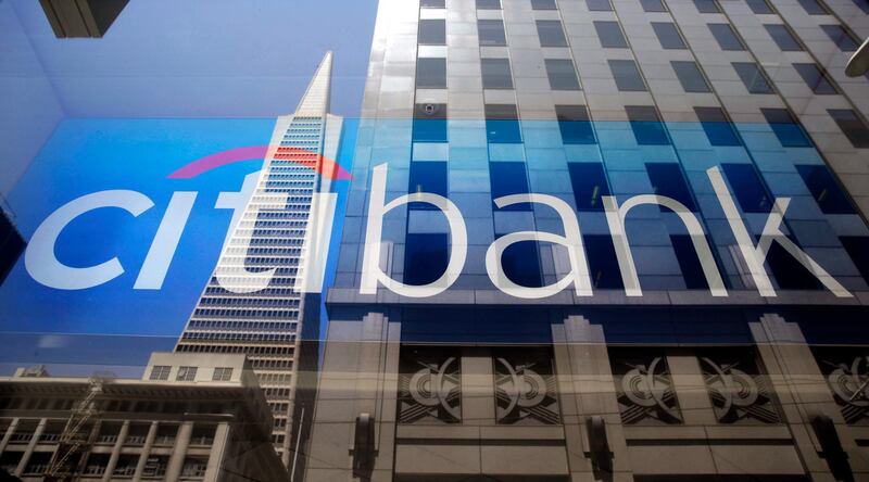 FILE - In this July 9, 2014, file photo, the Transamerica Pyramid is reflected in the window of the main branch of Citibank in the Financial District of San Francisco. The big Wall Street banks have been reporting billions of dollars in paper losses in January 2018, as they are forced to come into compliance with the new tax law. The biggest loser so far has been Citigroup, which reported an $18 billion loss, Tuesday, Jan. 16, 2018, largely due to the tax law. (AP Photo/Eric Risberg, File)