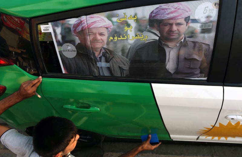 An Iraqi Kurdish man decorates a car with the Kurdish flag and a poster bearing the image of Iraqi Kurdish leader Massud Barzani urging others to vote in the upcoming September 2017 independence referendum, in Arbil, the capital of the autonomous Kurdish region of northern Iraq, on August 30, 2017.
Iraq's autonomous Kurdish region will hold a historic referendum on statehood in September 2017, despite opposition to independence from Baghdad and possibly beyond. / AFP PHOTO / SAFIN HAMED