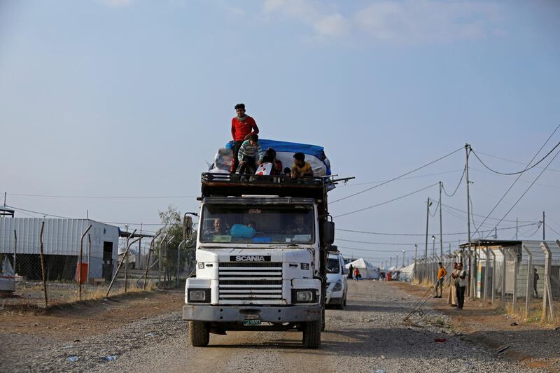 Displaced Iraqis ride on a lorry as they are evacuated from the Hammam Al Alil camp. Reuters