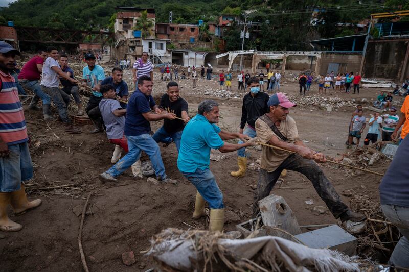 Residents attempt to remove the debris left behind by the landslide. EPA