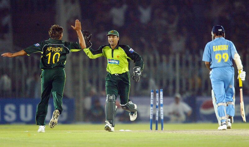 RAWALPINDI, PAKISTAN - MARCH 16:  Wicketkeeper Moin Khan (C) celebrates with bowler Shahid Afridi (L) of Pakistan after stumping Sourav Ganguly of India during the second Pakistan v India one day international match played at Pindi Cricket Stadium March 16, 2004 in Rawalpindi, Pakistan. (Photo by Scott Barbour/Getty Images)  