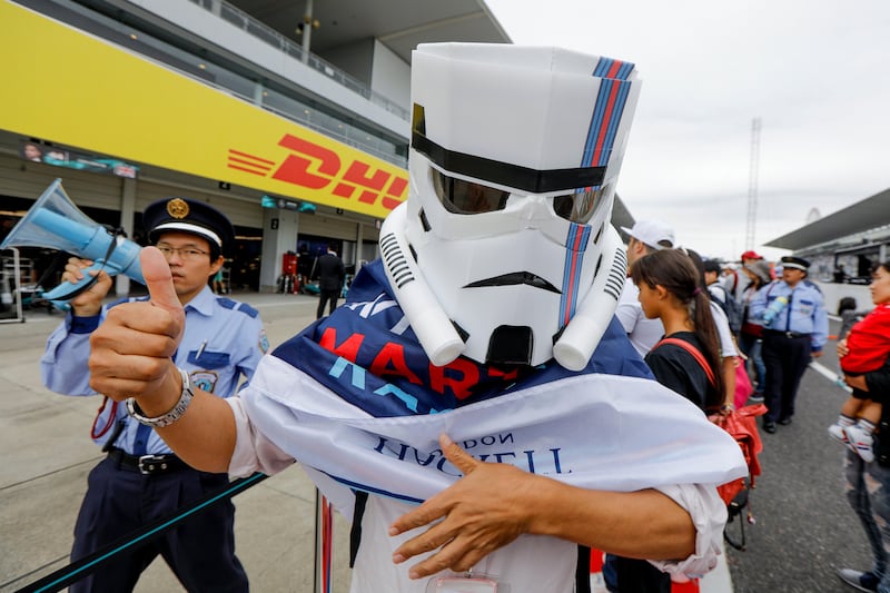 A Japanese Formula One fan wearing a home -made Star Wars mask with the colors of Williams Formula One team stands on the pit lane ahead of the Japanese Formula One Grand Prix at the Suzuka Circuit. Diego Azubel / EPA.