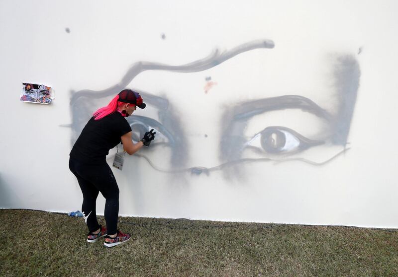 Dubai, United Arab Emirates - October 20, 2019: Graffiti artist Dina Saadi at the One year to go celebrations. Sunday the 20th of October 2019. Burj Park, Dubai. Chris Whiteoak / The National