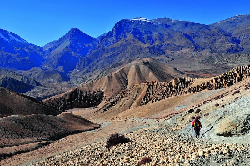 A trekker walks through the desiccated, spare landscape of Mustang, Nepal. Getty Images