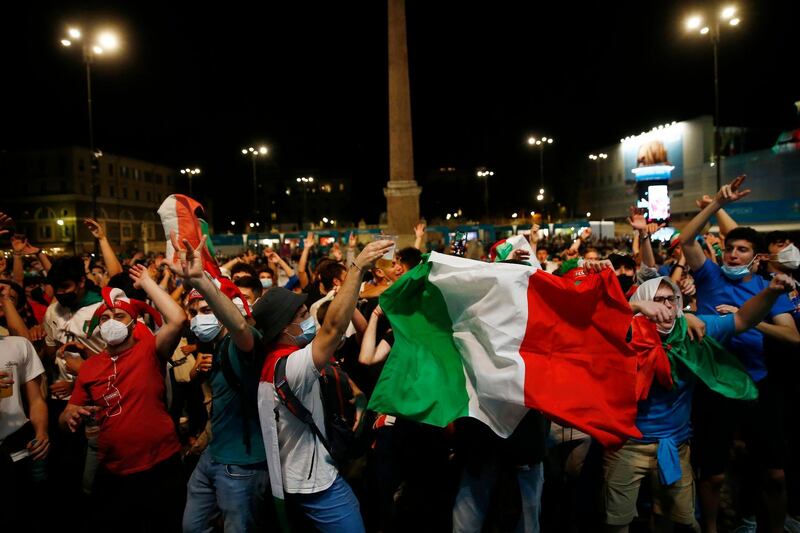 Italian fans celebrate while watching on a mega screen in downtown Rome,. AP