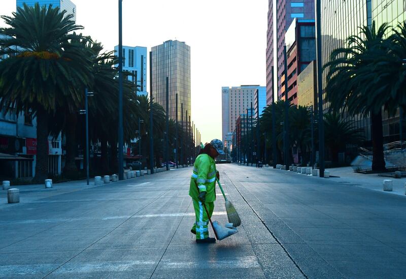 A worker cleans an empty avenue a day after the emergency decree in Mexico City, Mexico.  EPA