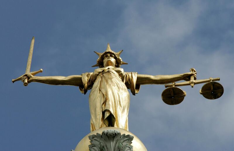 FILE PHOTO: The Statue of Justice is seen on top of the London Central Criminal Court, the Old Bailey, in London August 12, 2005./File Photo