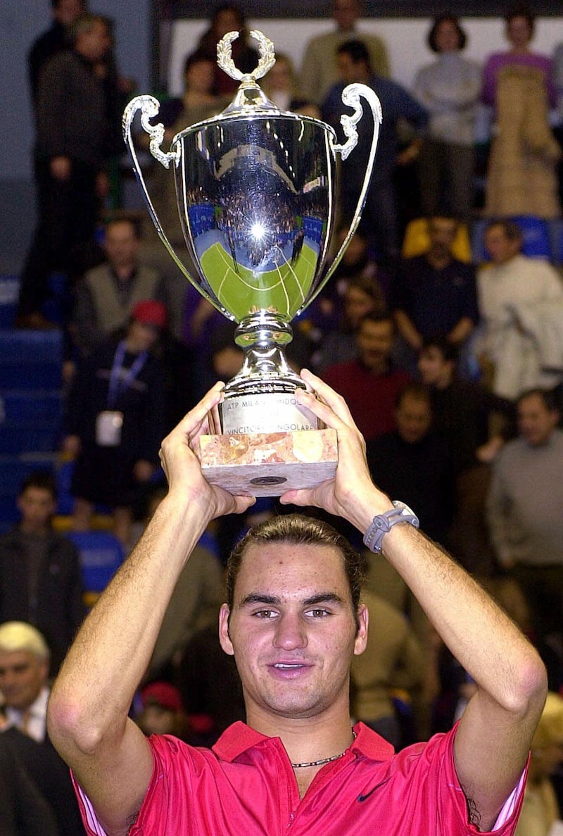 Roger Federer, of Switzerland, holds up the trophy after beating France's Julien Boutter, 6-4, 6-7 (7), 6-4 in the final of the Milan Indoors tennis tournament in Milan, Italy, Sunday, Feb. 4, 2001 . (AP Photo/Luca Bruno)
