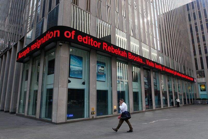 News about Rebekah Brooks resignation is displayed on the Fox News ticker at building which houses the News Corp. headquarter, Friday, July 15, 2011, in New York. Rupert Murdoch accepted the resignation of The Wall Street Journal's publisher and the chief of his British operations on Friday as the once-defiant media mogul struggled to control an escalating phone hacking scandal with apologies to the public and the family of a murdered schoolgirl. The controversy claimed its first victim in the United States as Les Hinton, chief executive of the Murdoch-owned Dow Jones & Co. and publisher of the Wall Street Journal, announced he was resigning, effective immediately. (AP Photo/Mary Altaffer) *** Local Caption ***  Britain Phone Hacking.JPEG-0f6b0.jpg