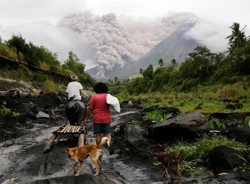 Filipino villagers walk along the slopes of rumbling Mayon Volcano as it spews ash in Legaspi city, Albay province, Philippines. Francis R. Malasig / EPA