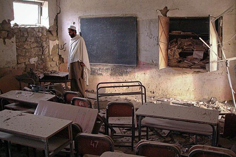 A man walks through a destroyed classroom of a boy's school hit by a bomb in Landikotal, northwest Pakistan November 23, 2011. Unidentified men planted a bomb that left classrooms partially damaged, police said. No casualties were reported.  REUTERS/Shahid Shinwari  (PAKISTAN - Tags: CIVIL UNREST CRIME LAW TPX IMAGES OF THE DAY EDUCATION)