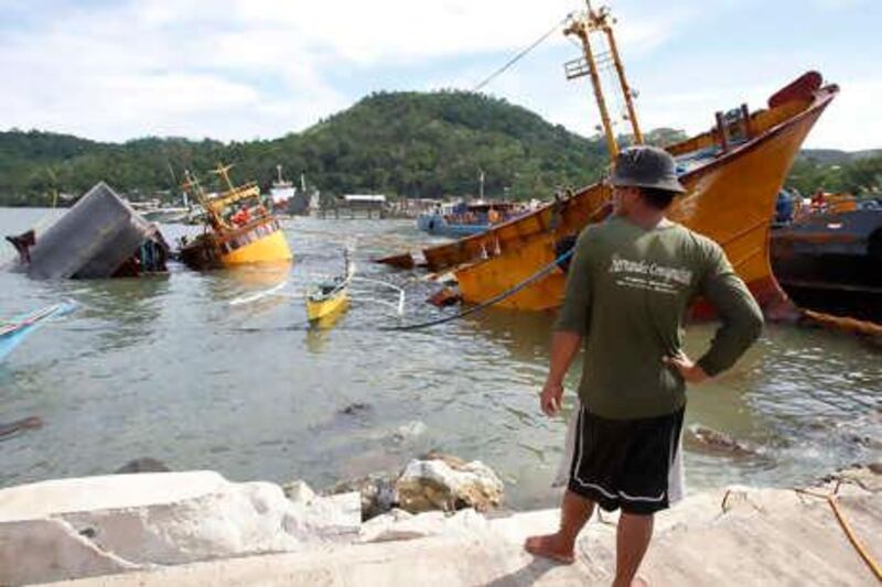 A resident looks at capsized ships and barges after Typhoon Conson hit Mariveles, Bataan, north of Manila July 15, 2010. Nine ships and and more than 20 fishing boats were reported sunk, and some run aground as Conson hit Bataan, local media reported. At least 26 people were killed and dozens were missing  after the typhoon lashed the Philippine main island of Luzon, government officials said. REUTERS/Erik de Castro (PHILIPPINES - Tags: SOCIETY DISASTER ENVIRONMENT)