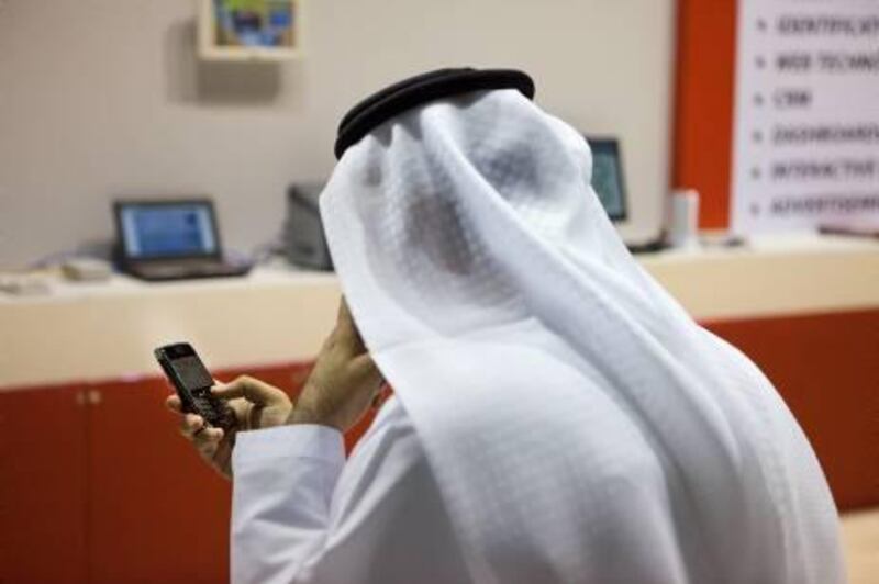 UAE - Dubai - Oct 12 - 2011: An eirati man usisng his BlackBerry during GITEX Technology Week at Dubai World Trade Centre (DWTC) ( Jaime Puebla - The National Newspaper )