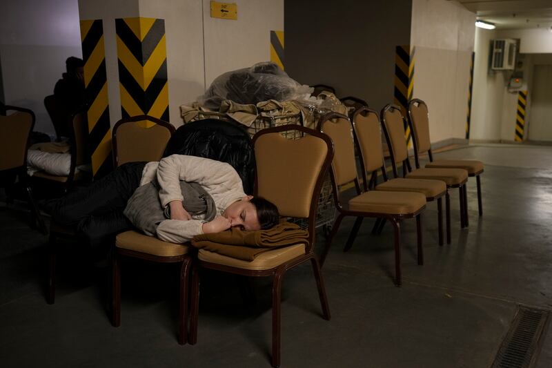 A woman sleeps on chairs in a Kiev bomb shelter. AP
