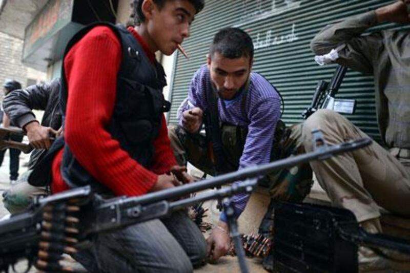 Syrian rebel fighters load weapons in the Sheikh Maqsud neighborhood in Aleppo last week.  Syrian rebels say they have been told access to weapons from Arabian Gulf states will be conditional on their pledging allegiance to the Free Syrian Army and its civilian overseers in the Syrian National Coalition. Dimitar Dilkoff / AFP