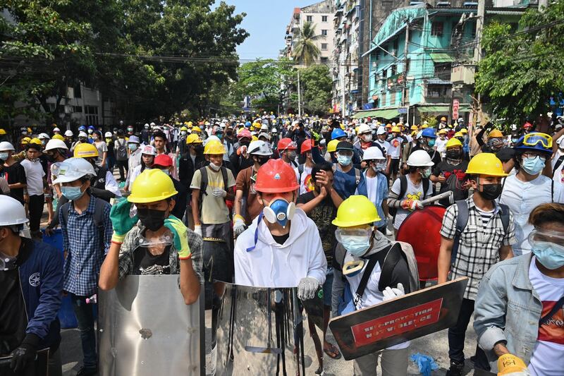 Anti-coup protesters wearing protective gear gather on a road during a demonstration in Yangon. AFP