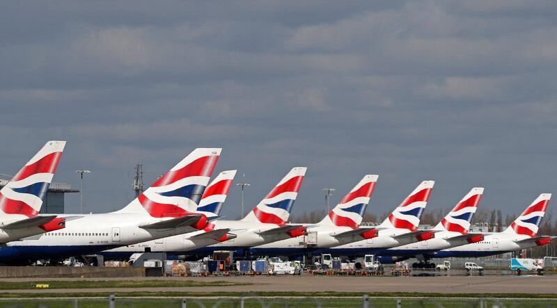 (FILES) This file photograph taken on March 16, 2020 This picture shows British Airways aircraft grounded at Heathrow Airport terminal 5, in west London. IAG, the owner of British Airways and Spanish carrier Iberia, said February 26, 2021, that it suffered a 2020 net loss of 6.9 billion euros ($8.4 billion) as the coronavirus pandemic paralysed air travel. The huge loss after tax compared with a net profit of 1.7 billion euros in 2019, IAG said in a results statement. Revenues slumped almost 70 percent to 7.8 billion euros from 25.5 billion euros as passenger capacity was slashed.
 / AFP / Adrian DENNIS
