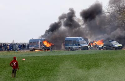 Gendarmerie vehicles burn as protesters attend a demonstration in Sainte-Soline. Reuters 