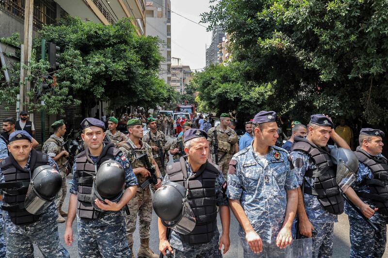 Army soldiers, behind, and security forces, front, stand guard outside the bank in Beirut. AFP